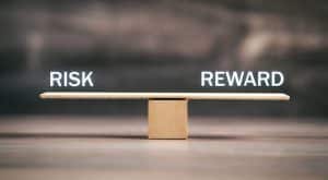 Risk and Reward on wooden scales.