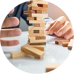 Hands balancing wooden blocks to show risk management and stability